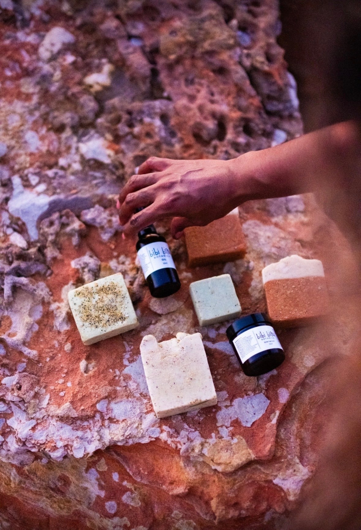 Botanical oil and ointment arranged on coastal rock