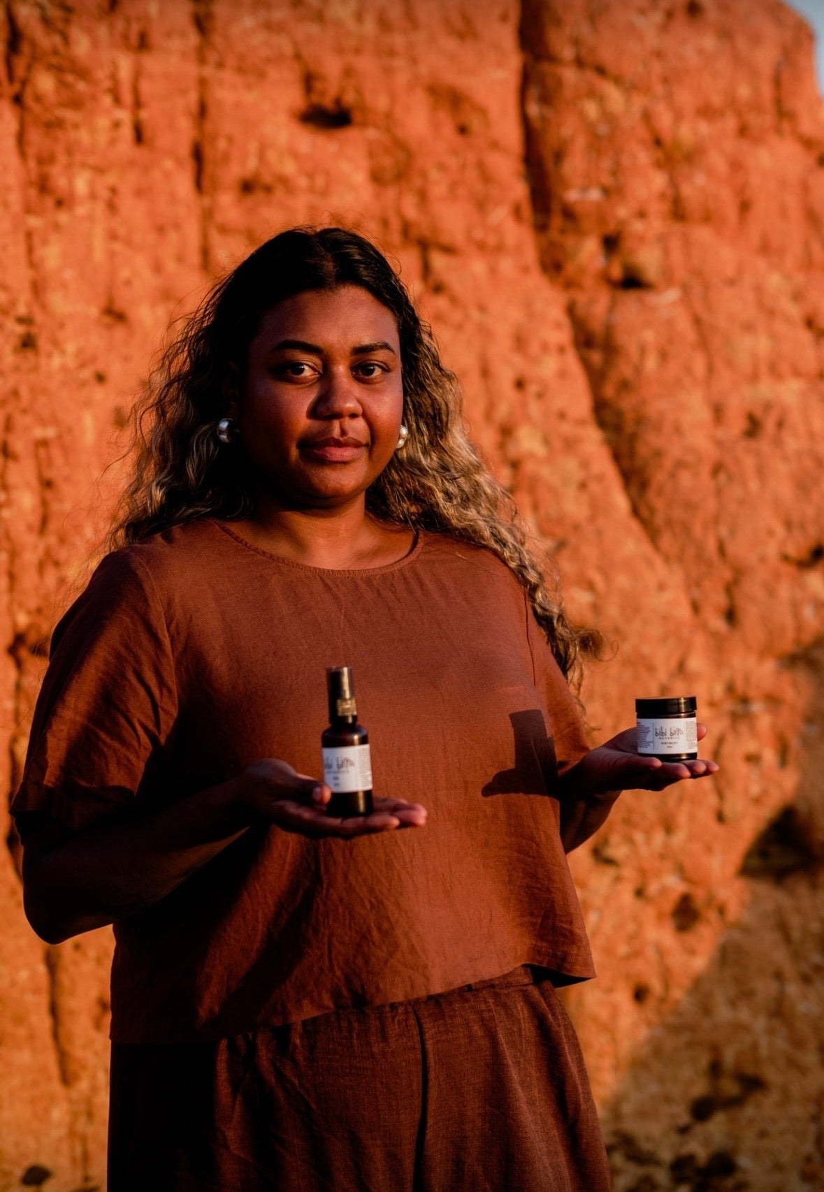 Family member holding oil and ointment against the red cliffs